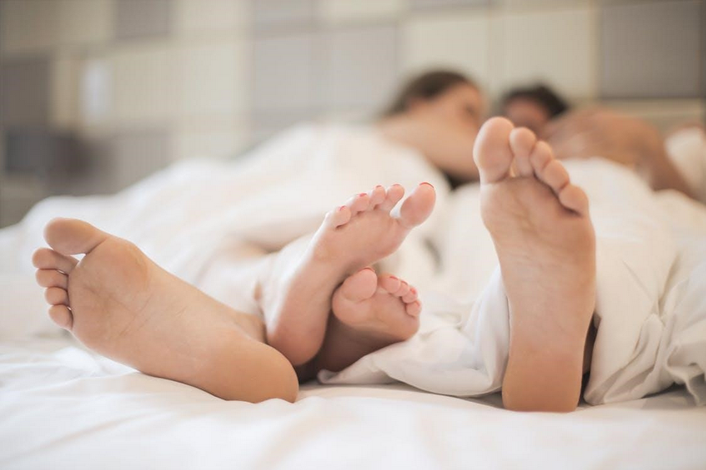 feet of couple in love in bed